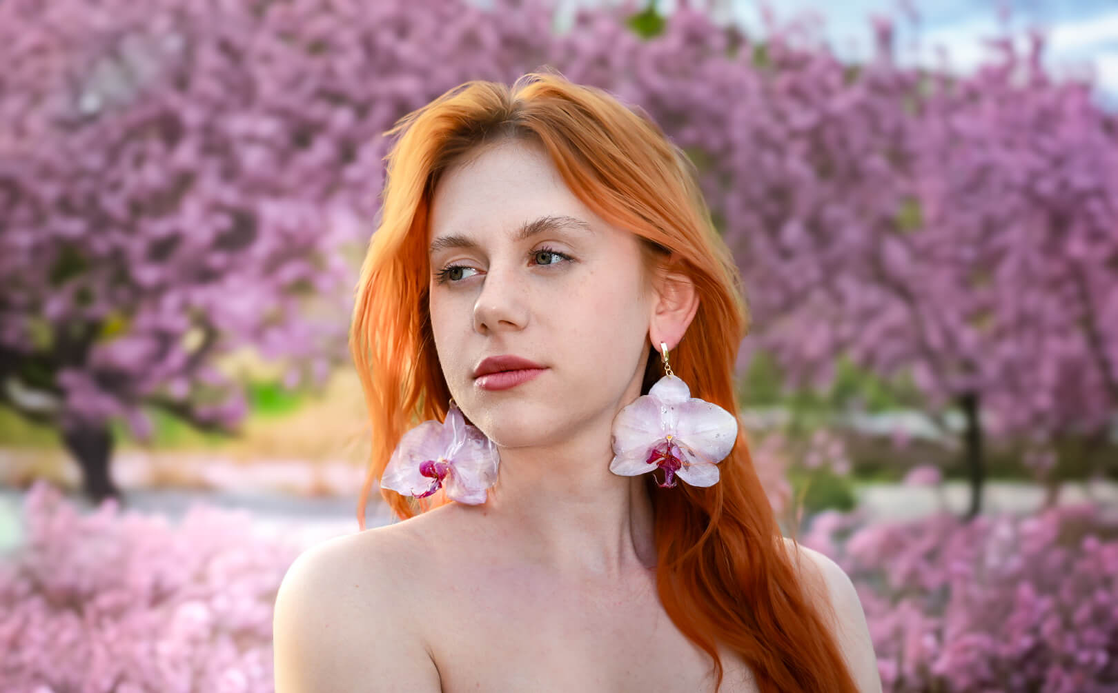 Kolczyki z prawdziwą orchideą w transparentnej oprawie migoczące w świetle, przypominające krople rosy.